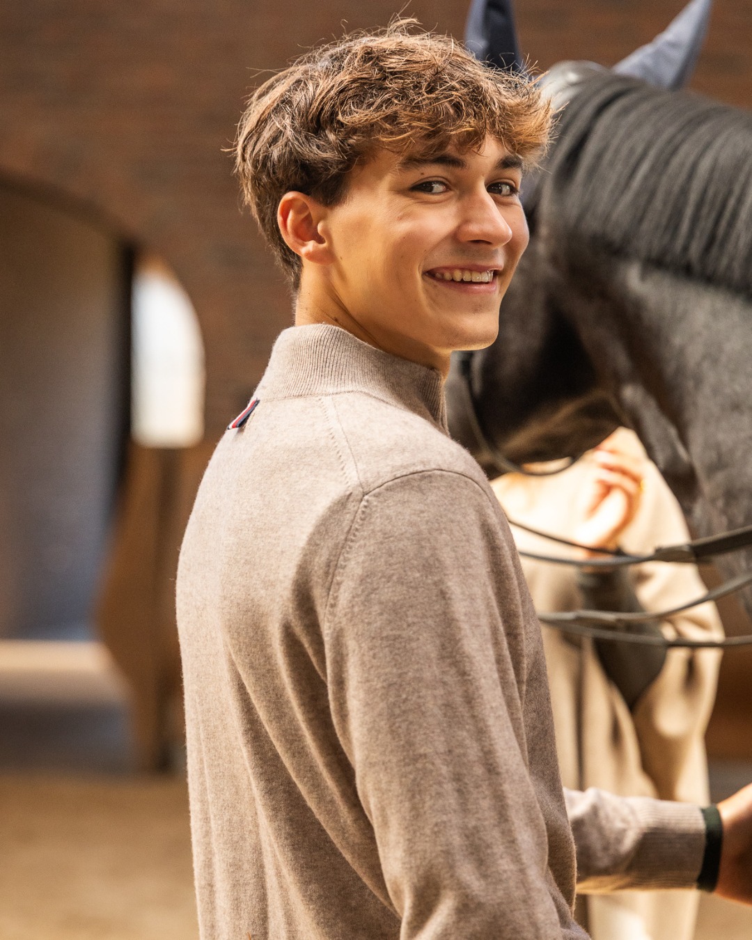 Portret van Robin Cooijmans in de stal met een paard